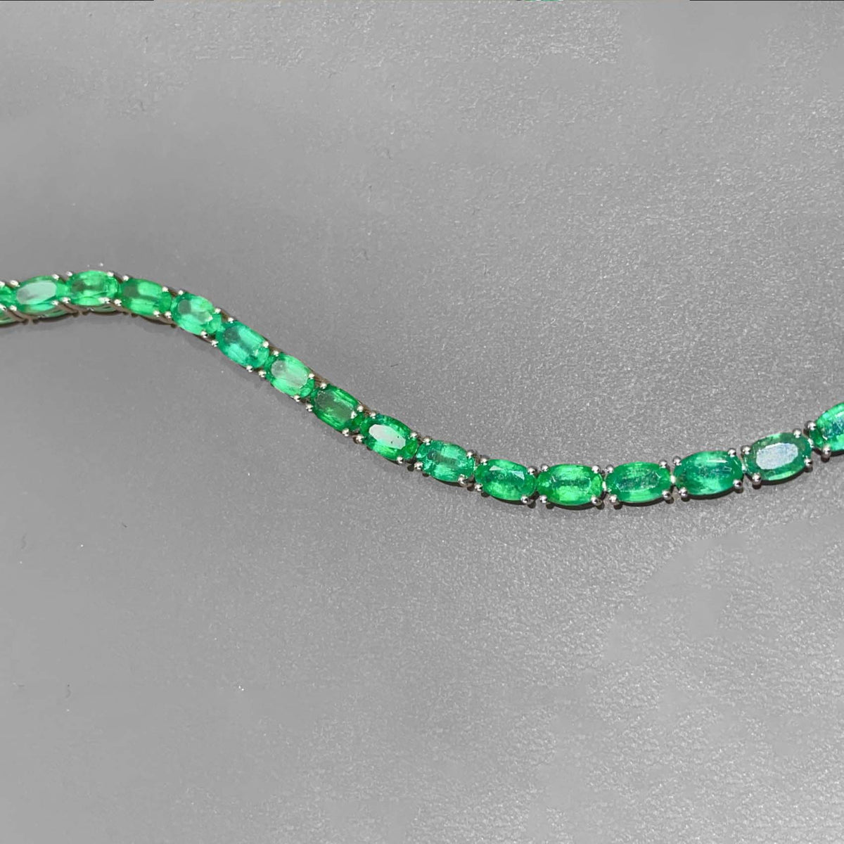 8.0ct oval cut emerald tennis bracelet in 18k white gold