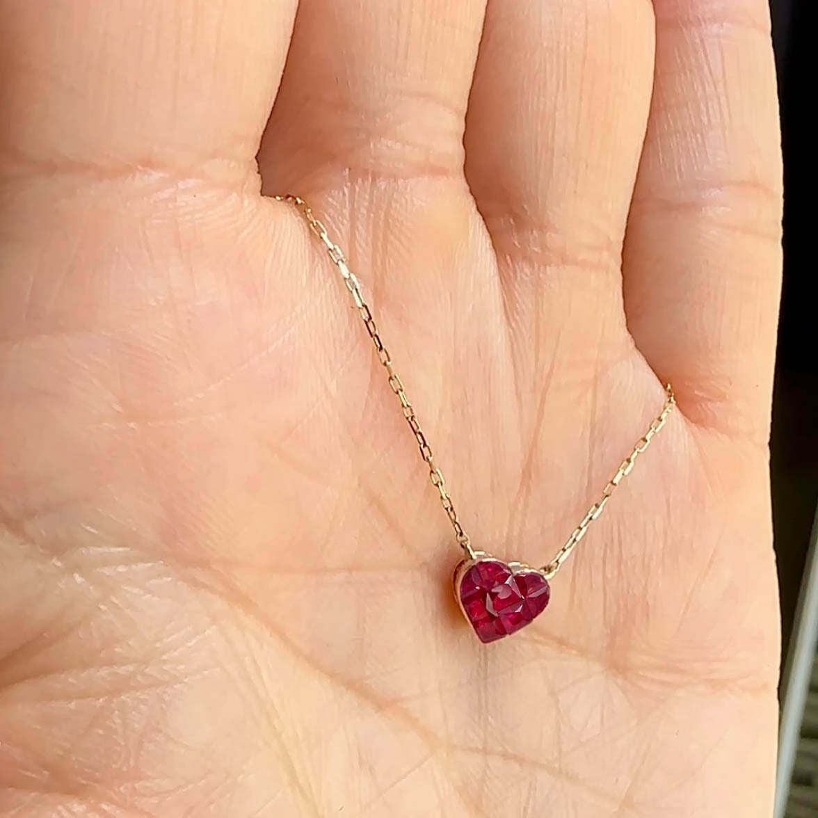 0.5ct ruby by heart necklace in 18k gold on hand