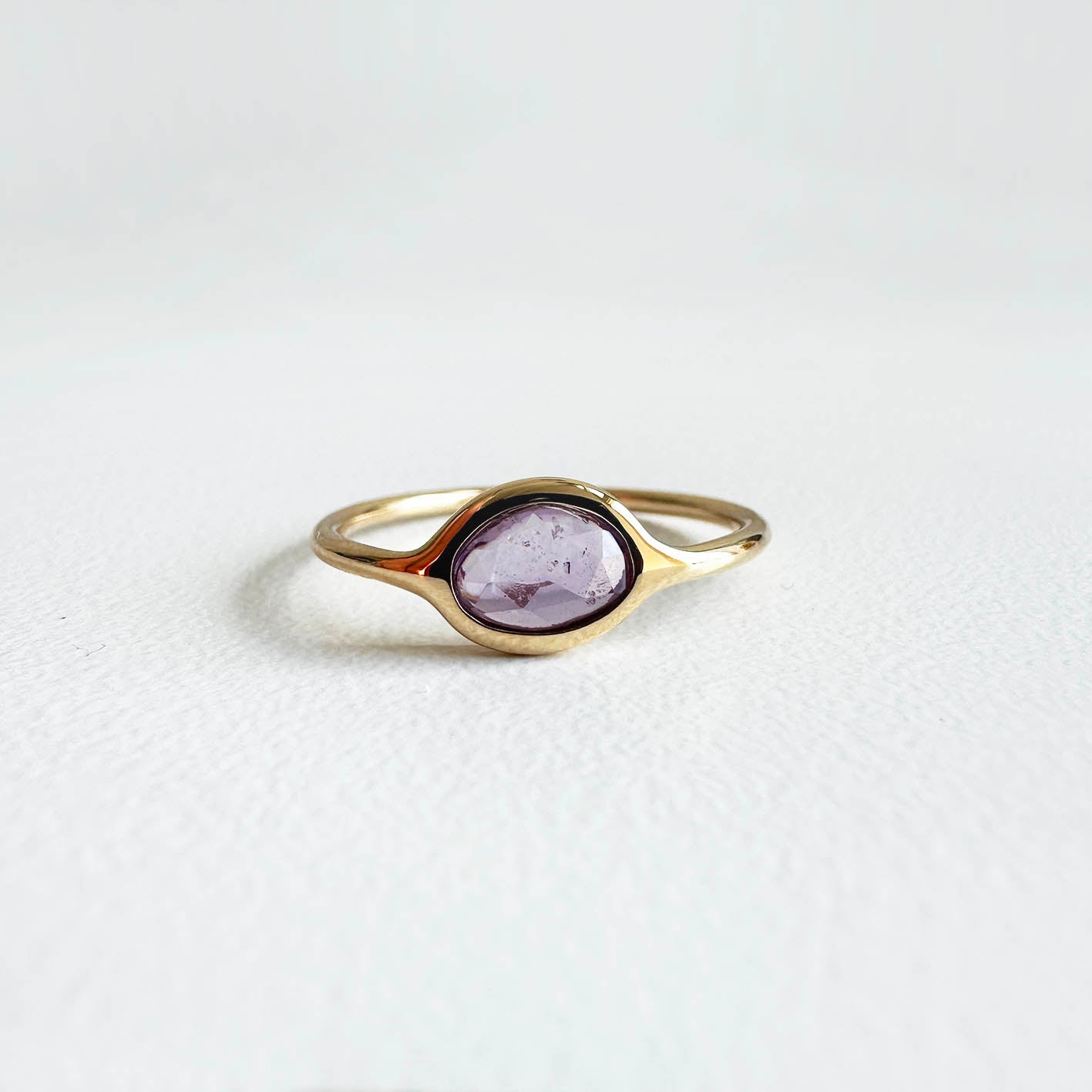 love more 0.56ct pink sapphire ring in 18k gold on table