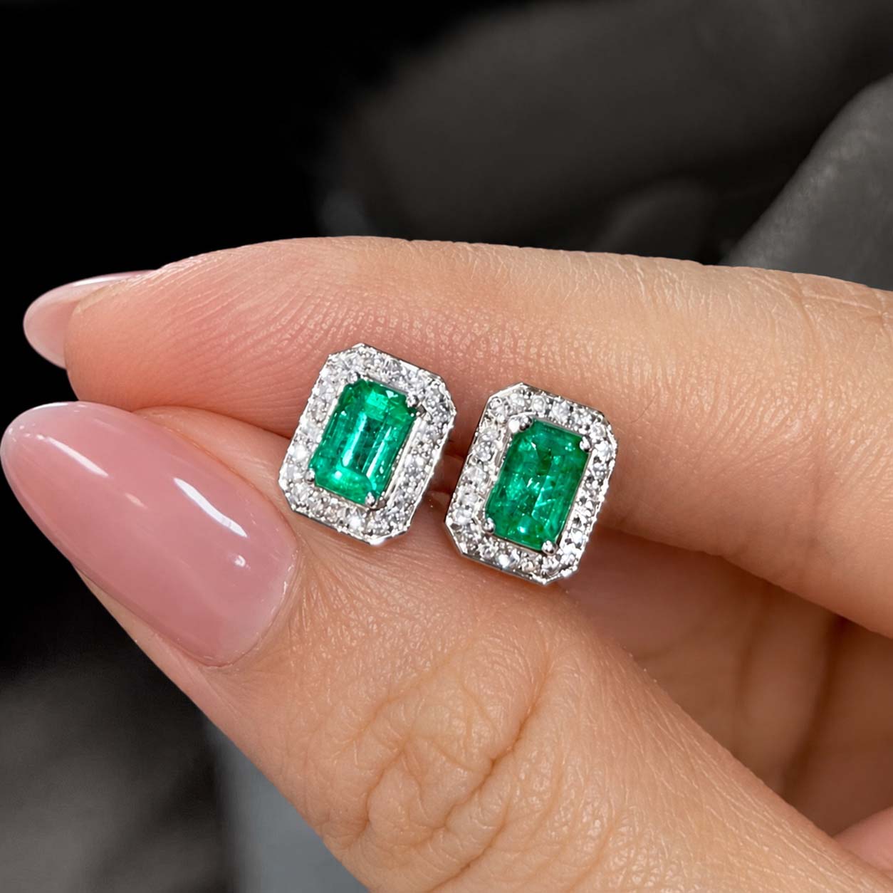 1.2ct emerlad diamond halo earrings in 18k white gold on hand