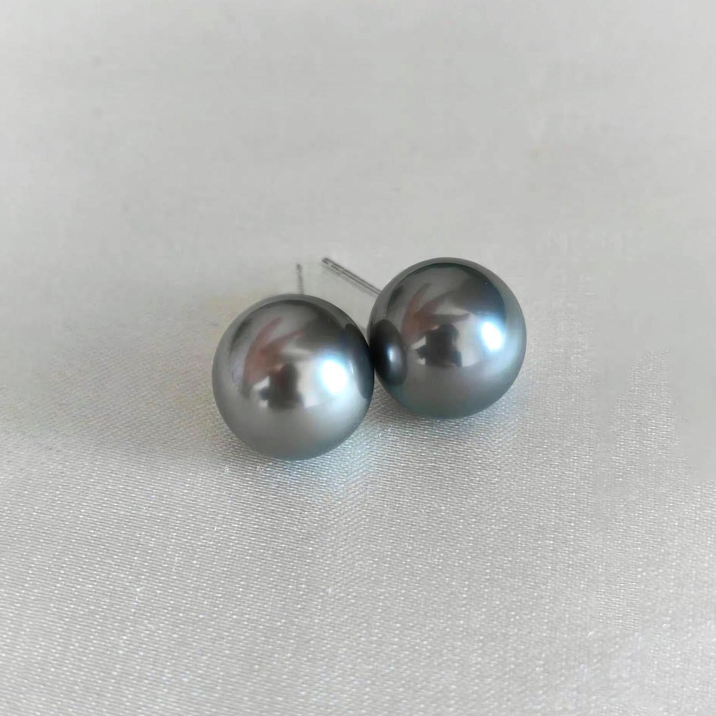 12mm grey tahitian pearl earrings in 18k white gold on table