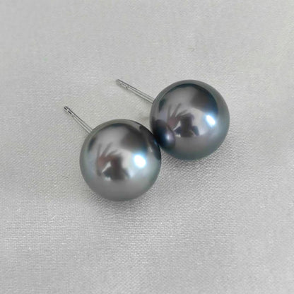 12mm grey tahitian pearl earrings in 18k white gold on table