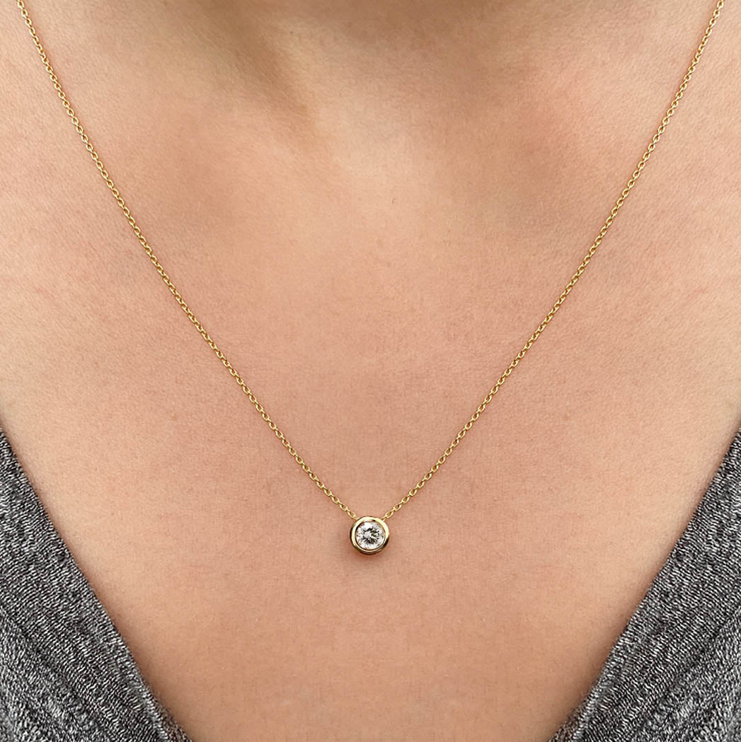 0.15ct diamond bezel necklace in 18k gold on neck