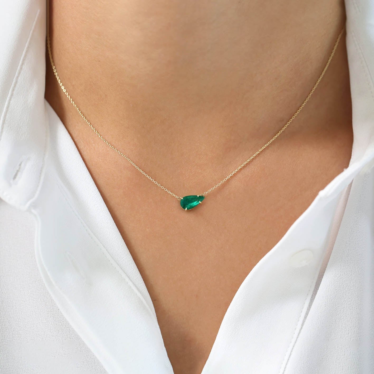 1ct pear cut emerald necklace in 18k gold on neck