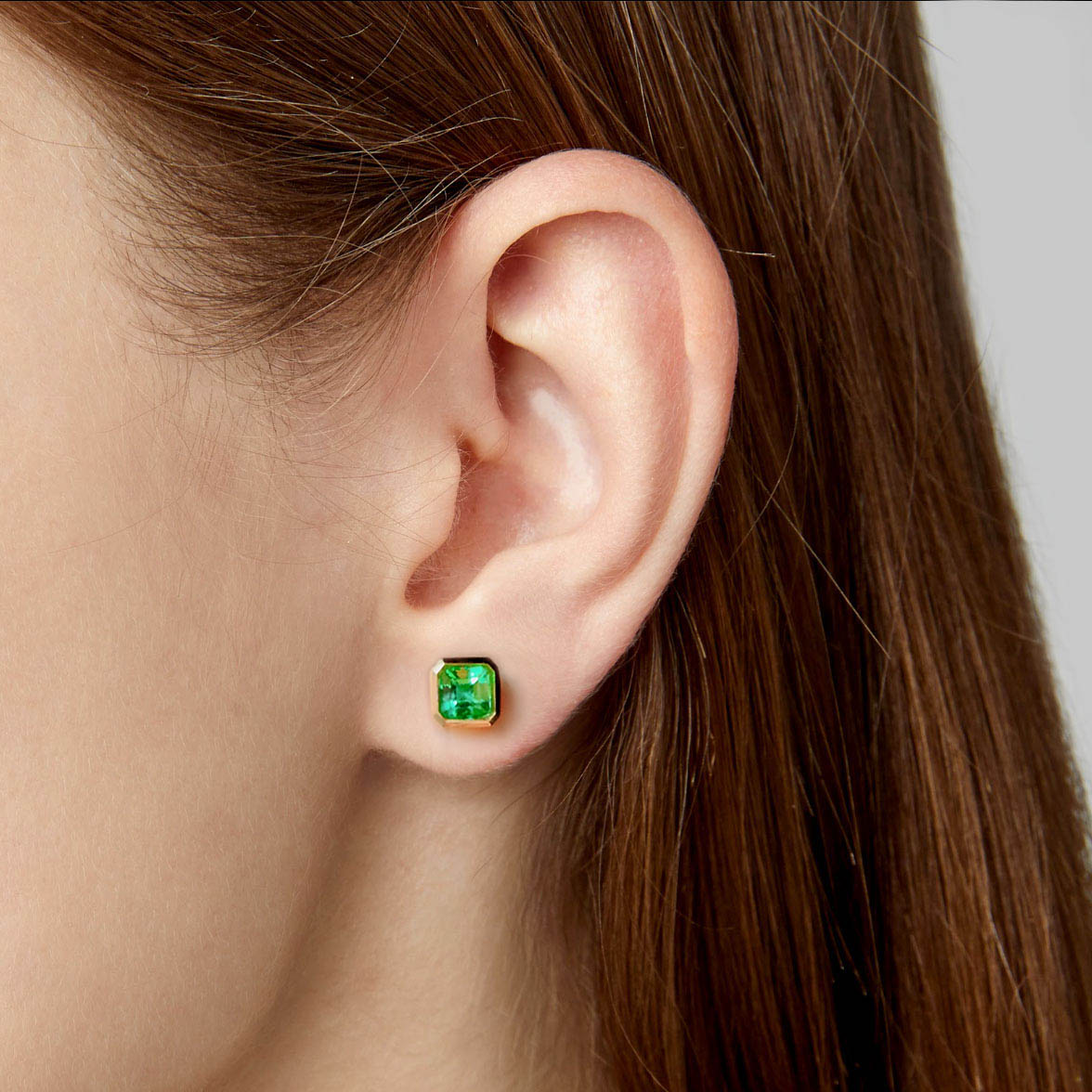 0.87ct bezel set asscher emerald earrings in 18k gold on ear