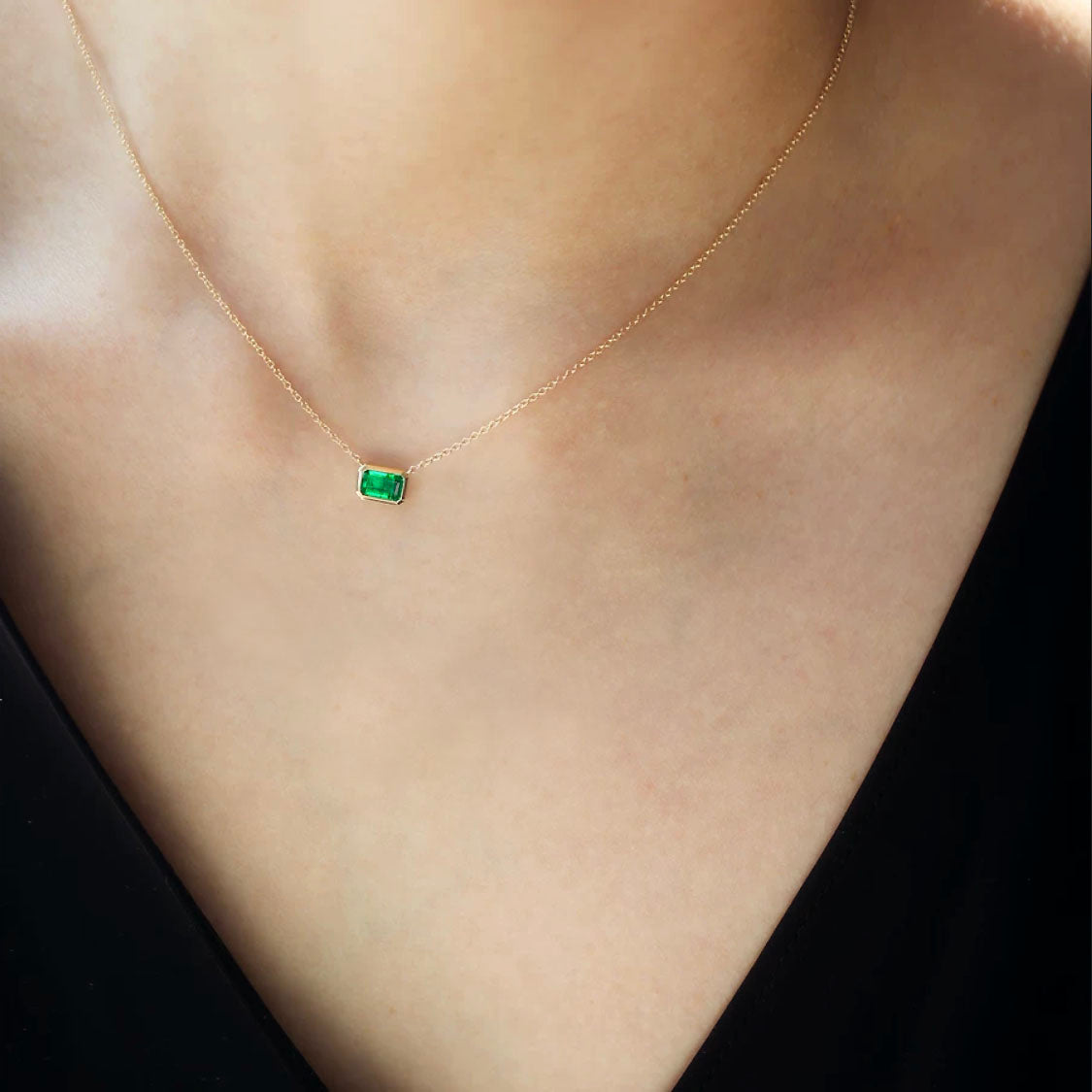 bezel set emerald necklace in 18k gold on neck