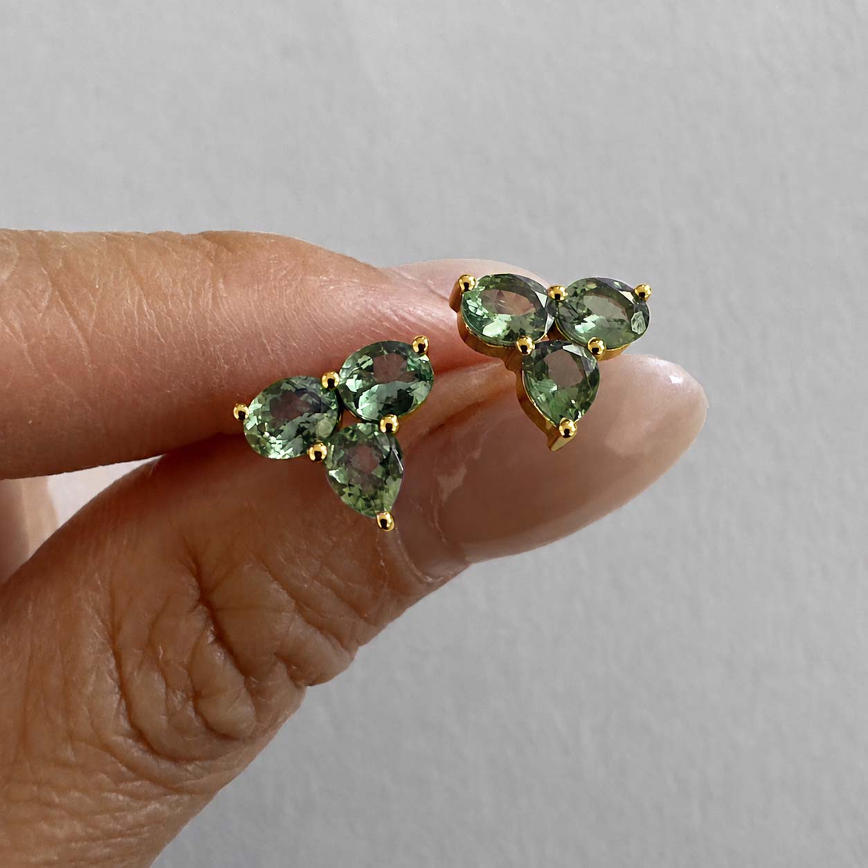eden small green sapphire earrings in 18k gold on hand