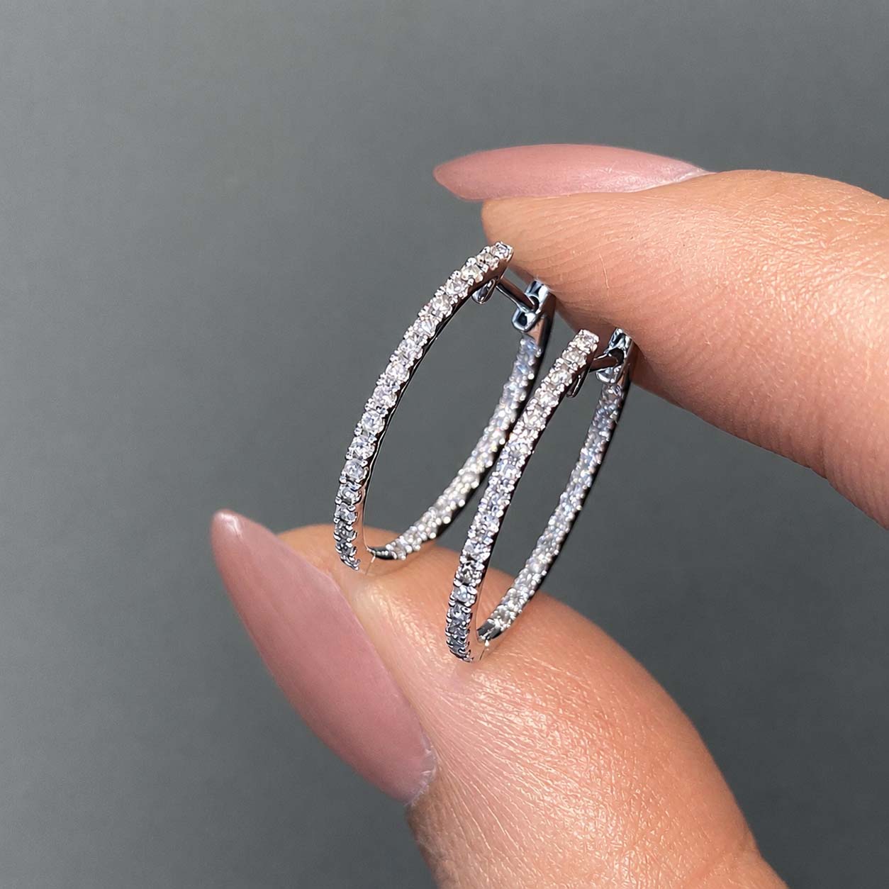 embrace 0.6ct diamond oval hoop earrings in 18k white gold on hand