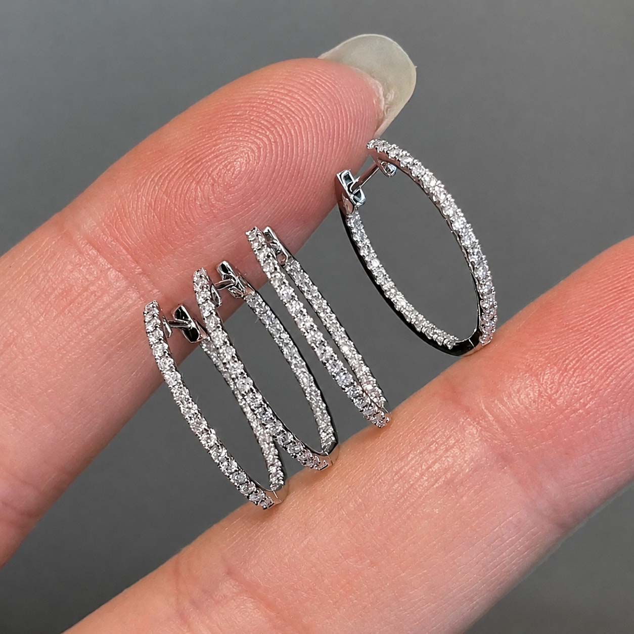embrace 0.6ct diamond oval hoop earrings in 18k white gold on hand