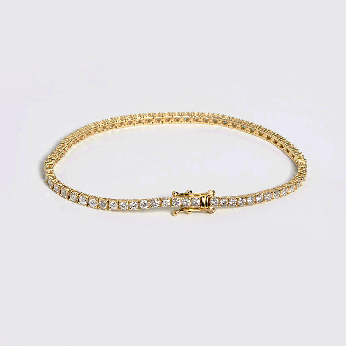 embrace 2ct diamond tennis bracelet in 18k gold on table