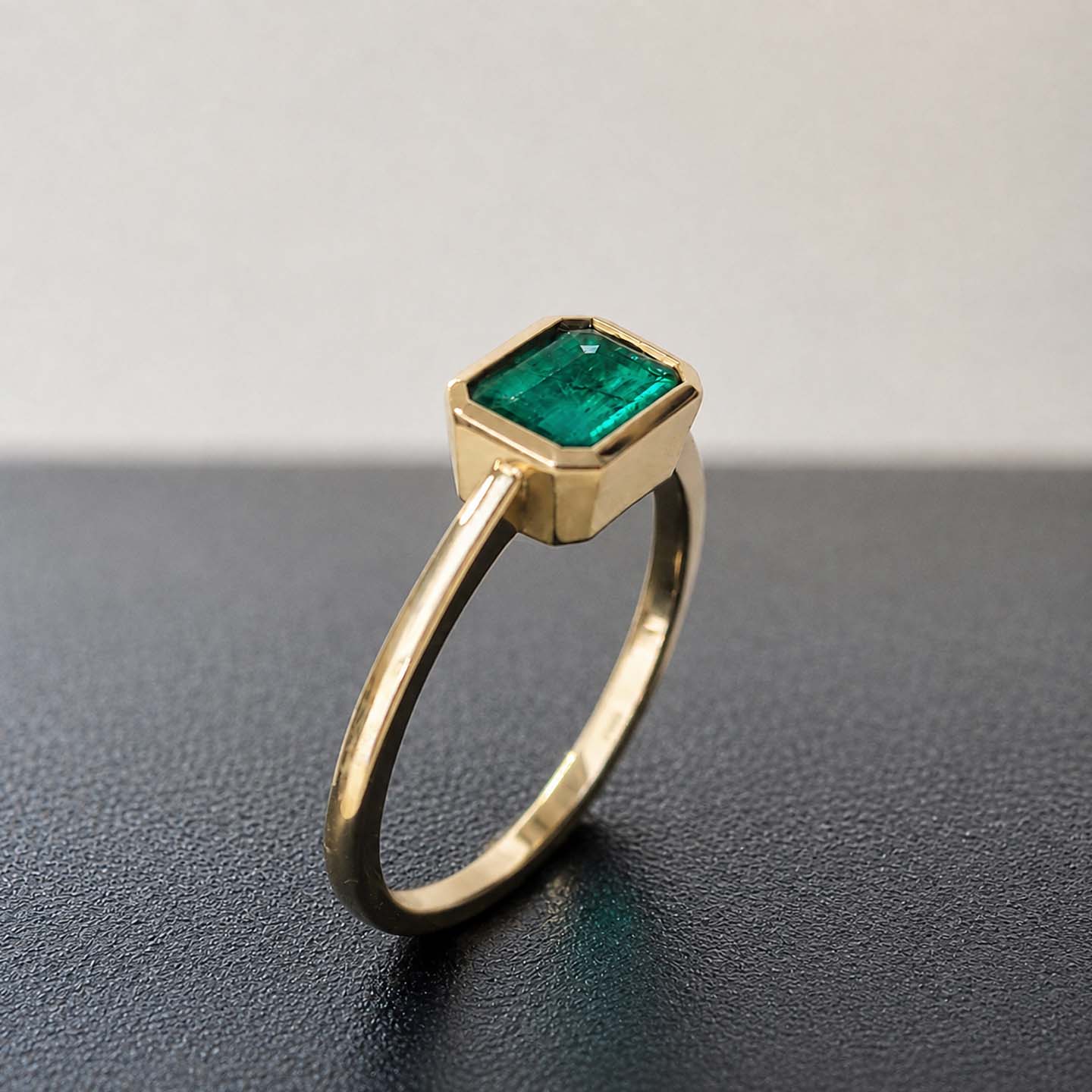 1.0ct step cut emerald ring in 18k gold