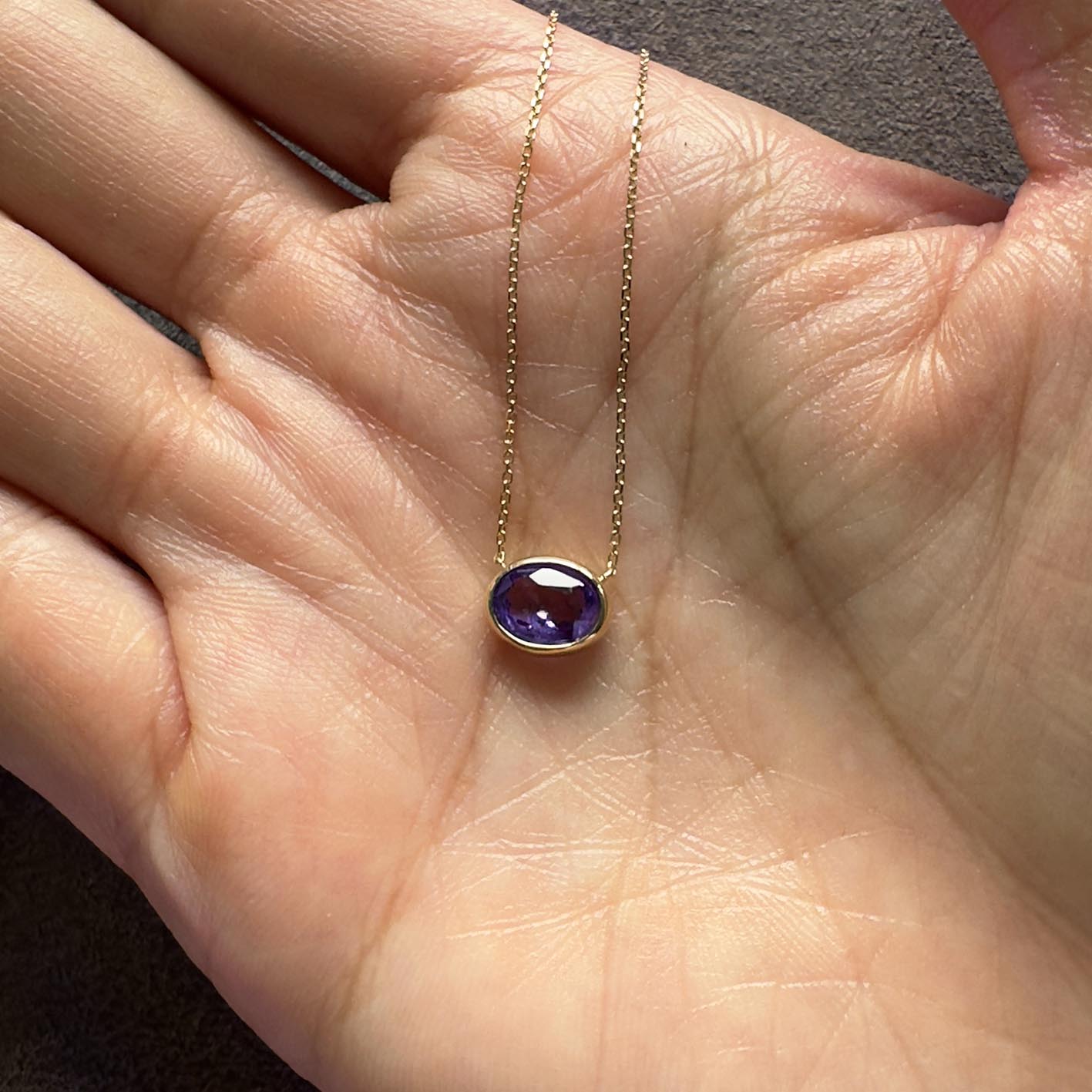 love more bezel set oval purple sapphire necklace in 18k gold on hand