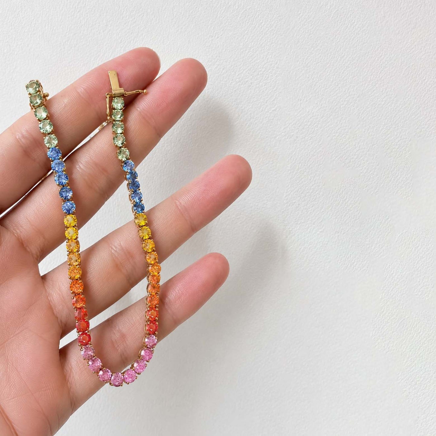 one of a kind 7.8ct rainbow sapphire tennis bracelet in 18k gold on hand