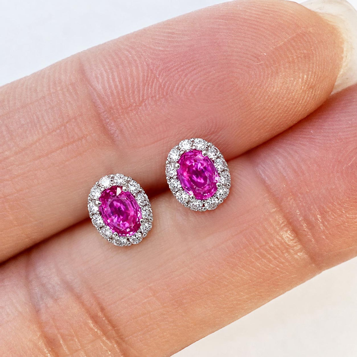 one of a kind 0.91ct pink ruby diamond halo earrings in 18k white gold on hand