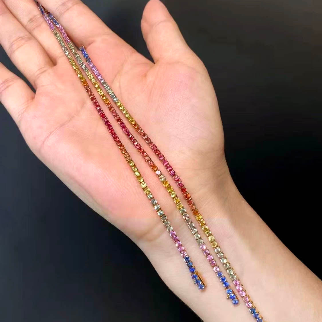 one of a kind rainbow sapphire bracelet in 18k gold on hand