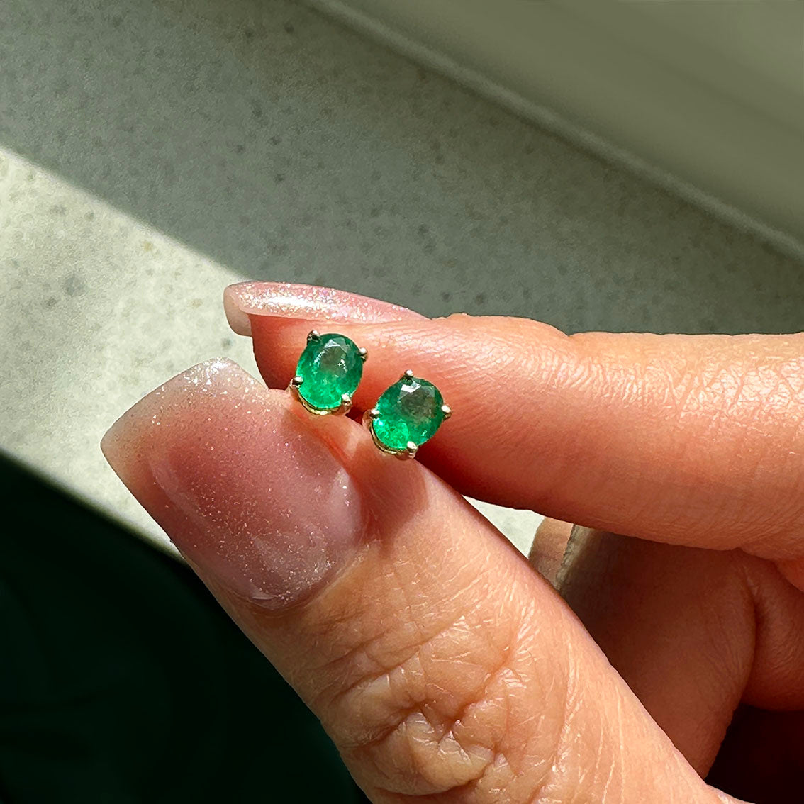 oval emerald earrings 18k gold under sun light
