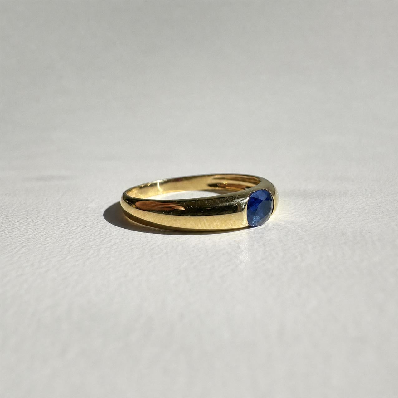 single tulip oval sapphire ring in 18k gold side view