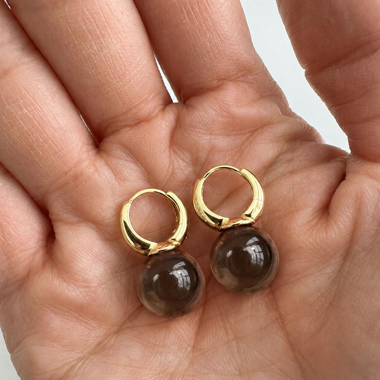 jullie smoky quartz ball earrings in 18k gold plated sterling silver on hand