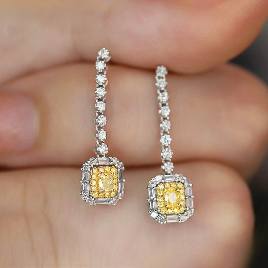 yellow diamond emerald shape earrings in 18k white gold on hand